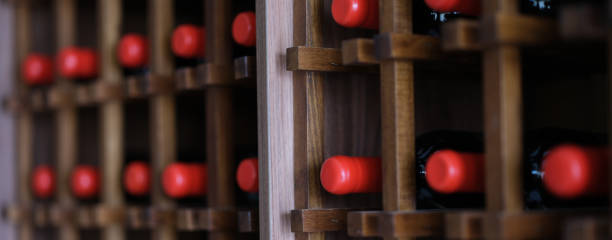 istock Group of red wine bottles stacked on wooden racks 1456726145