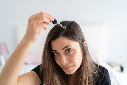 Retrato de aplicar suero para el cabello a su cabello photo