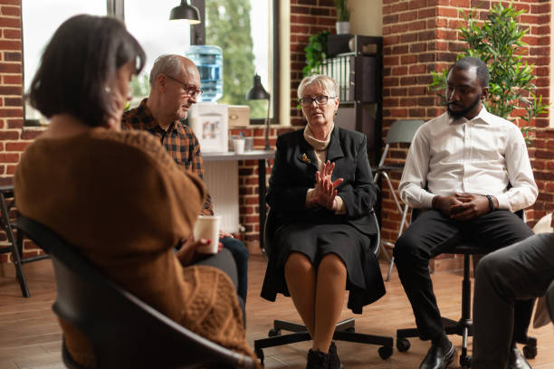 istock Woman therapist having support discussion with people at aa group meeting 1456730152