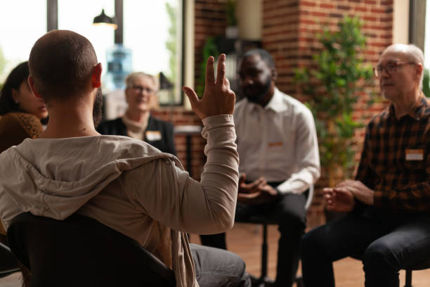 istock Man with addiction sharing health problems with group at aa meeting 1456730309