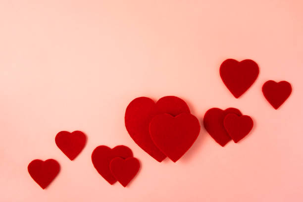 Red heart shaped felts on pink background