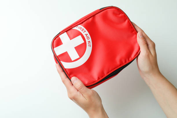 istock Female hands hold first aid medical kit on white background 1456731919