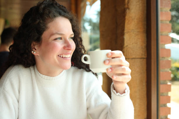 istock Happy woman drinking coffee looking away 1456732317