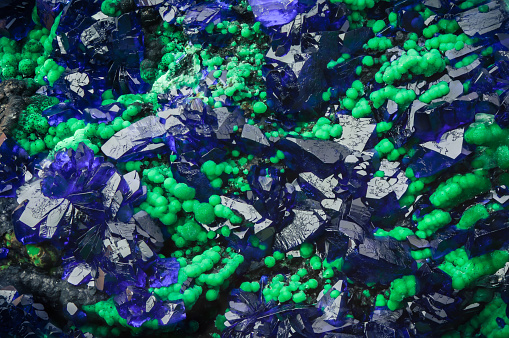 azurite blue crystal on green malachite, macro detail texture background. close-up raw rough unpolished semi-precious gemstone
