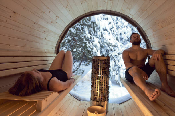 Caucasian adult couple enjoying in the sauna in winter stock photo