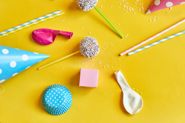 Festival birthday background with delicious homemade popcake coconut chocolate cake pops on a yellow background, festival desserts, tasty food
