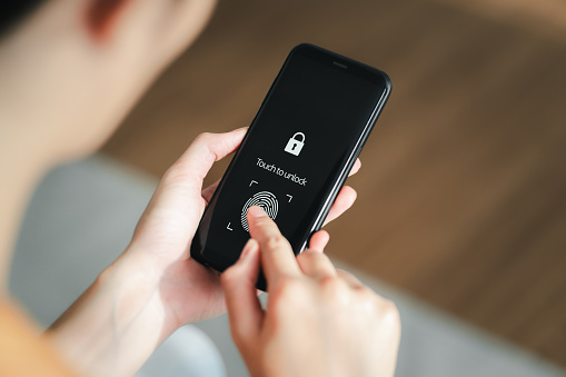 Woman using Smart phone with application for scanning fingerprint. Cyber security of personal device.