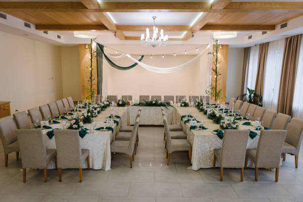 istock Wedding arch is decorated with textile fabric and garlands with light bulbs in restaurant. Festive dinner table, reception. Flower composition and candles. Setup. Setting in banquet area in hall. 1456739914