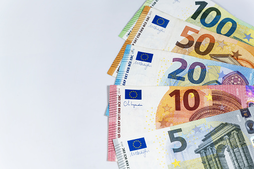 Fan of banknotes in euro currency on a light gray background, money and finance concept, copy space, selected focus