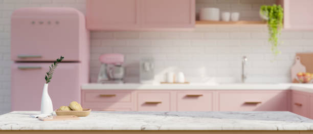 Copy space on white marble tabletop in beautiful pastel pink kitchen with pink kitchen appliances
