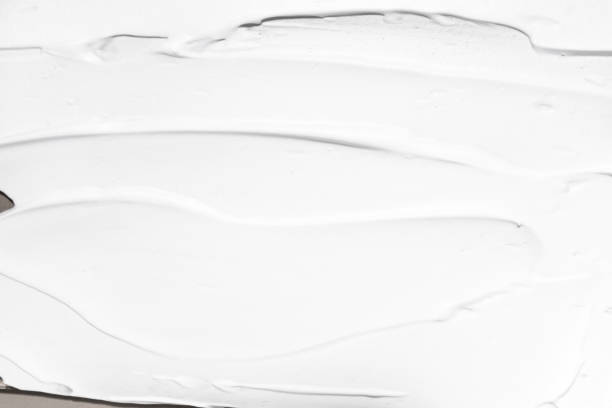 istock White cosmetic cream applied in large strokes top view. Abstract beauty background. 1456743289