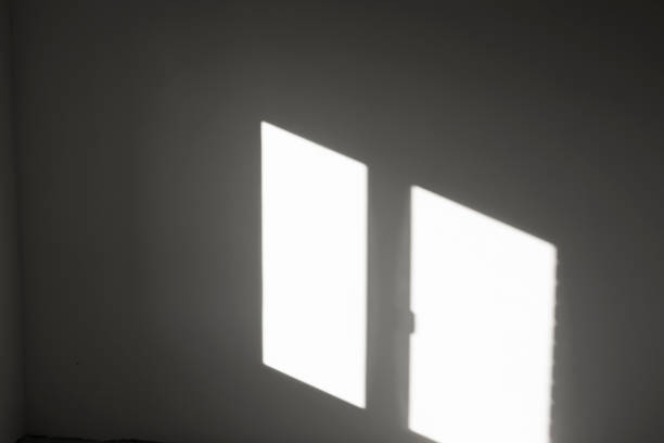 istock Reflection of sunlight from a window opening on the wall, abstract background with geometric lines in an empty room. 1456743323