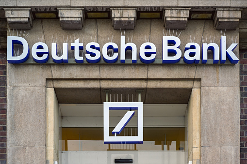 Lubeck Travemunde, Germany, January 15, 2023: Portal of Deutsche Bank (meaning German Bank) with lettering and sign on a historic building, spikes against pigeons and other birds on the letters