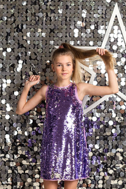 portrait teen cover girl in disco dress posing at bright background with star, looking at camera. pretty party girl with hairstyle in silver wear. retro music style concept. copy text space for ad - pre teen boy flash imagens e fotografias de stock