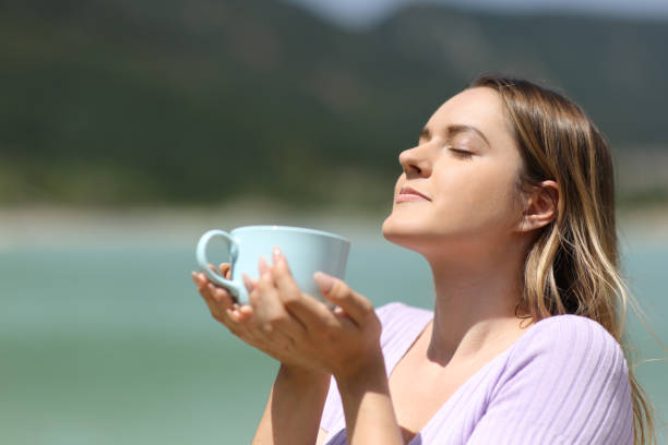 istock Woman in nature smelling coffee 1456747420