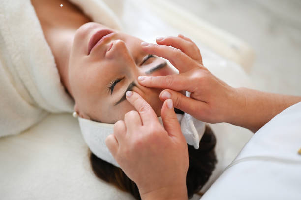 mujer recibe masaje de estiramiento facial - health spa women spa treatment massager fotografías e imágenes de stock