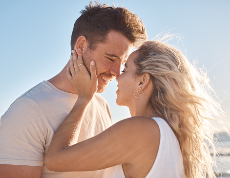 Love, couple and beach holiday, vacation or summer date and honeymoon outdoors. Affection, romance and smile of man and woman ready for kiss, having fun and enjoying quality time together at seashore