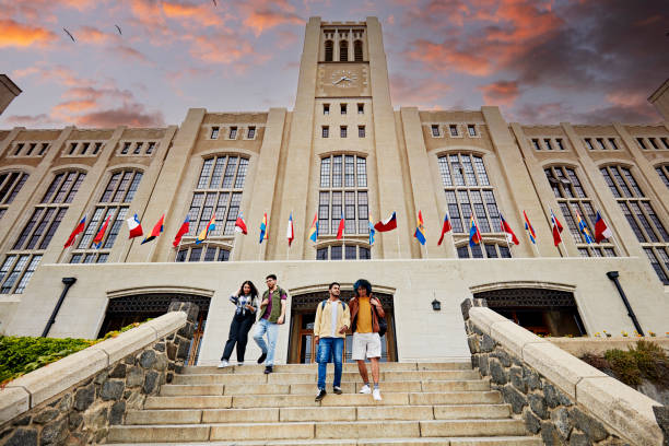 College students leaving school at sunset stock photo