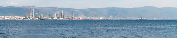 Tüpraş oil refinery factory by the sea. Panoramic view of oil refinery plant in sunny day. Kocaeli, Turkey - January 16, 2023. Selective focus