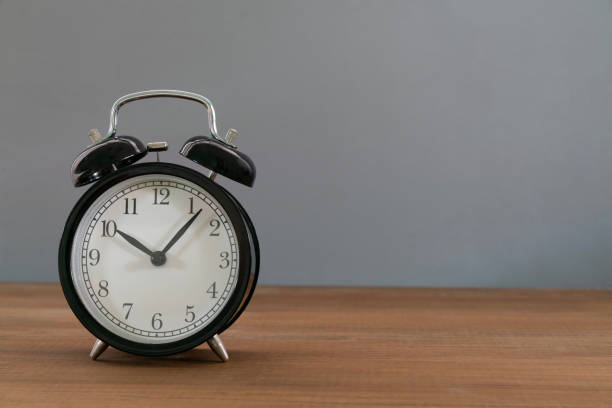 istock Retro alarm clock on gray table background, vintage style. 1456752776