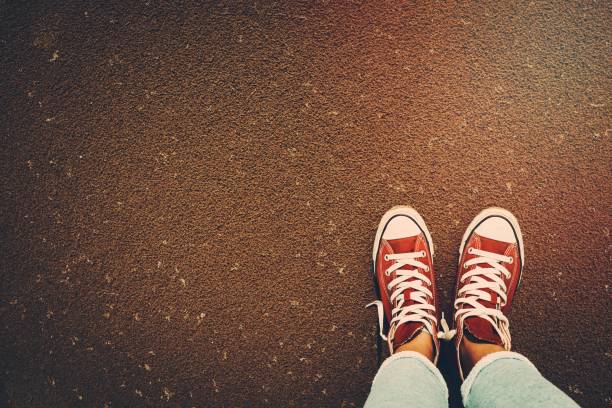 Photo of a red gumshoes over sand background, stylish shoes for active people, urban youth lifestyle
