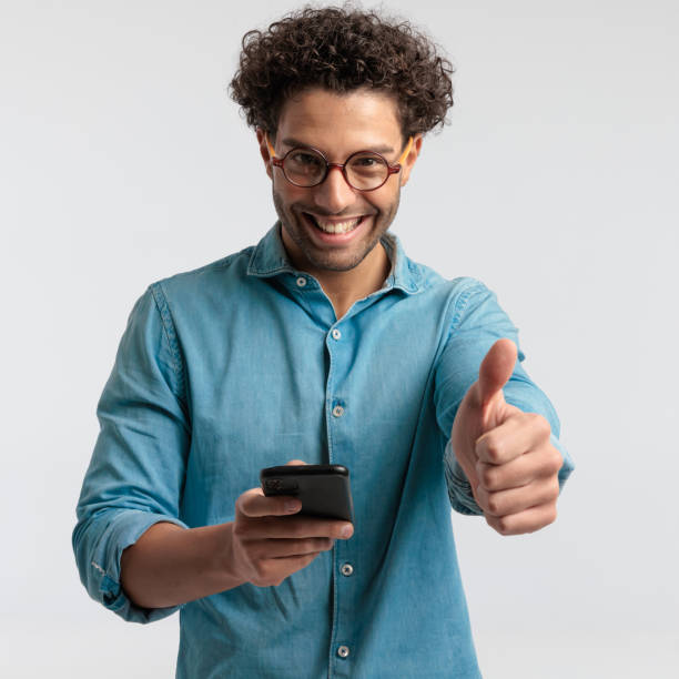 istock casual man texting on his phone and giving a like 1456754705
