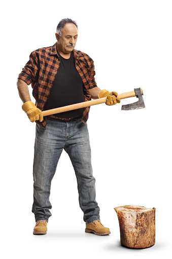 Full length portrait of a mature man cutting wood with an axe isolated on blue background