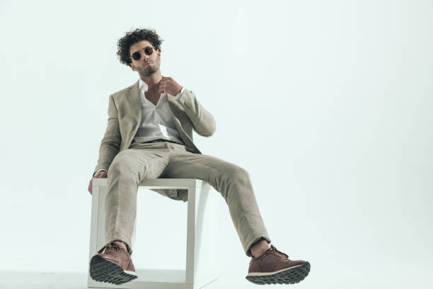istock curly hair man with sunglasses adjusting shirt collar and posing 1456757441