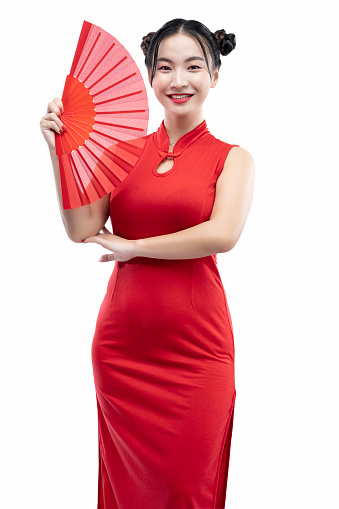 Asian Chinese woman in a cheongsam dress holding a red Chinese fan isolated over white background