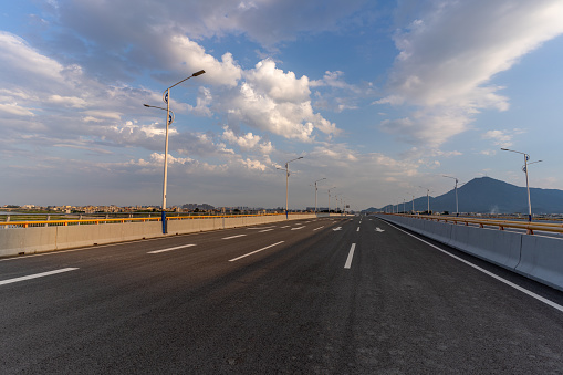 An empty asphalt road leading to a distant diminishing view