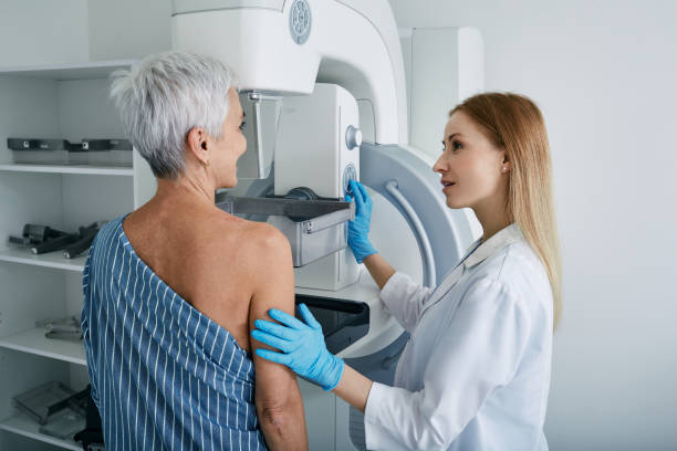 ältere frau mit mammographie-scan im krankenhaus mit medizintechniker. mammographie-verfahren, brustkrebsprävention - medizinischer test stock-fotos und bilder