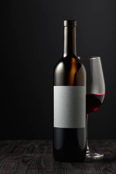 istock Bottle and glass of red wine on a black table. 1456761628