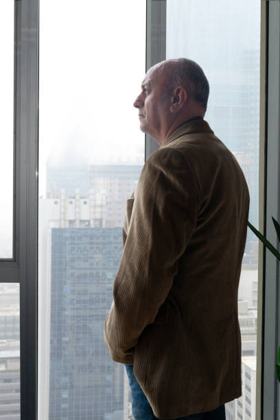 istock Businessman looking out the office window 1456761687