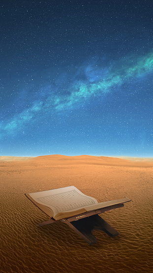 Opened Quran on a wooden placemat in the desert with a night scene background