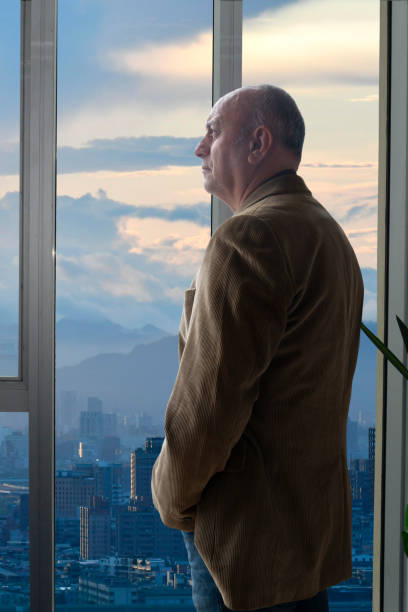 istock Businessman looking out the office window 1456762190