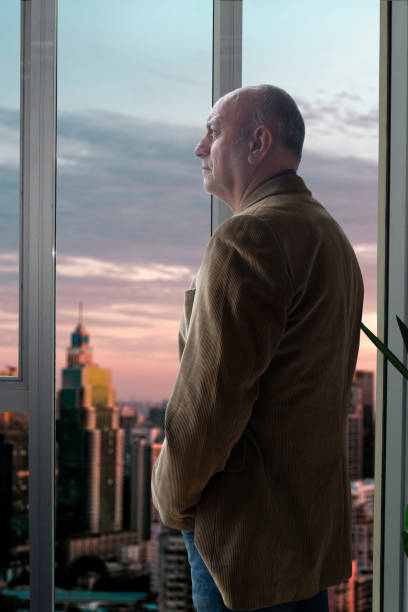 istock Businessman looking out the office window 1456762191