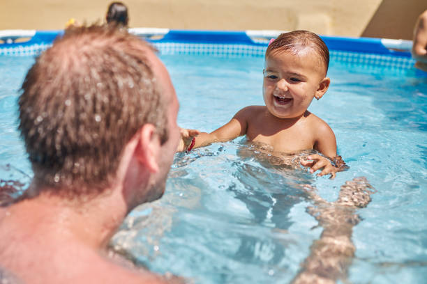 istock Father and daughter playing in swimming pool 1456762896