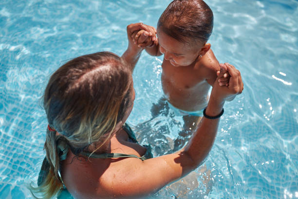 istock Mother and daughter playing in swimming pool 1456763022