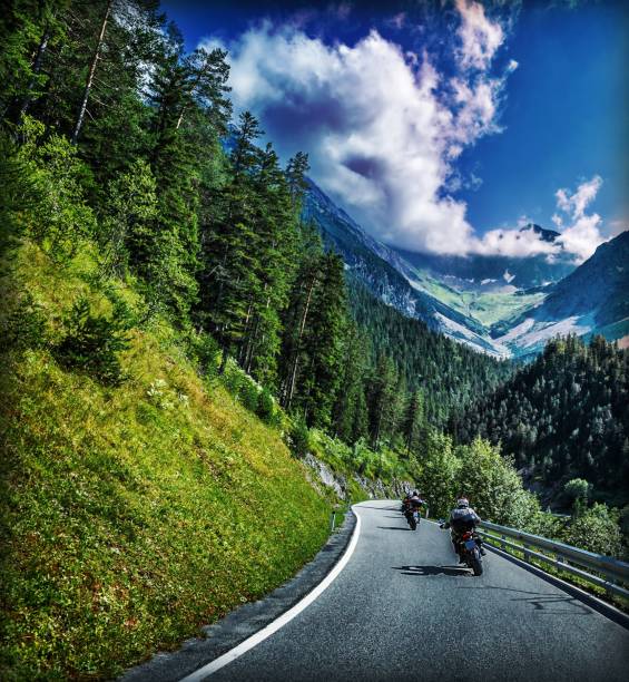 Motorbikes race, group of sportive people travel on motorcycles in Alpine mountains, enjoying extreme sport, active lifestyle concept