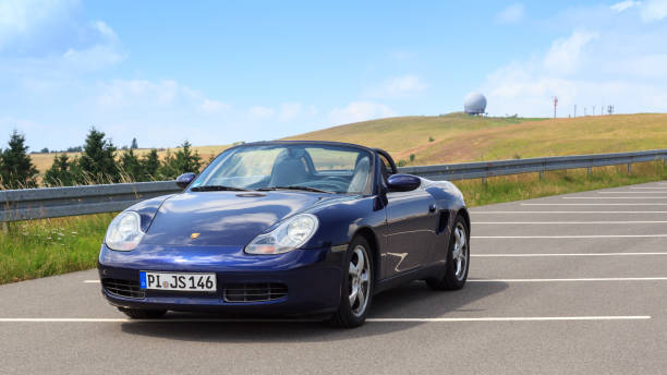 roadster azul porsche boxster 986 con panorama wasserkuppe y cúpula de radar en las montañas rhön. - germany landscape nissan roadster fotografías e imágenes de stock