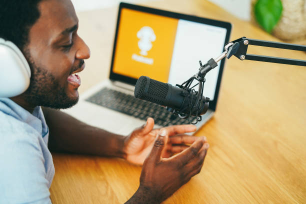 istock African man live streaming podcast session at home studio - Focus on microphone 1456768562