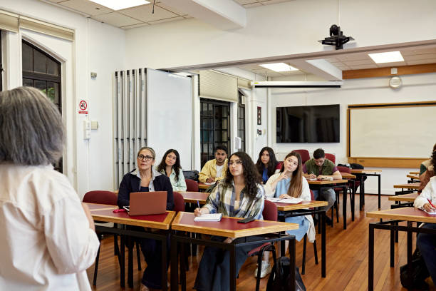 istock Mixed age group listening to female educator in classroom 1456770483