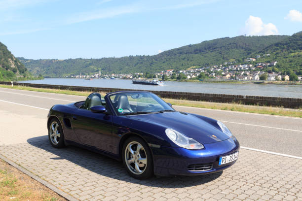 niebieski roadster porsche boxster 986 z panoramą wąwozu renu. samochód jest dwumiejscowym samochodem sportowym z centralnie umieszczonym silnikiem produkowanym przez niemiecką firmę motoryzacyjną porsche. - germany landscape nissan roadster zdjęcia i obrazy z banku zdjęć