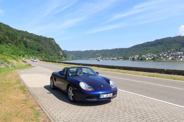 roadster azul porsche boxster 986 con panorama de la garganta del río rin. el automóvil es un automóvil deportivo biplaza de motor central fabricado por la compañía automotriz alemana porsche. - germany landscape nissan roadster fotografías e imágenes de stock