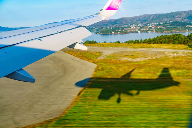 View from an airplane to jet wing and norwegian fjords landscape. Jet is landing. Aviation business