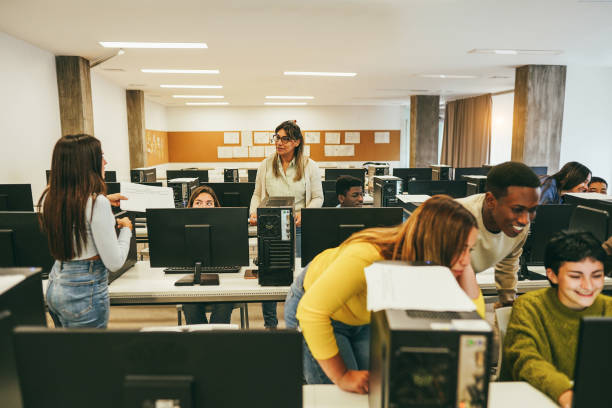 istock Teacher working with students inside computer class room - Focus on mature woman face 1456773739