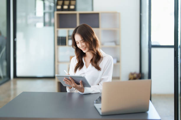 istock business owner or Asian female marketers are using tablet computer in office work 1456775107
