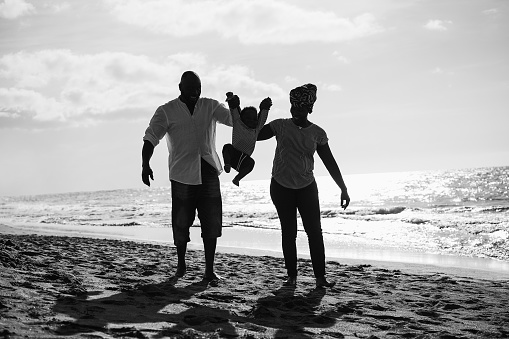 African family having fun on the beach in summer vacation - Black and white editing