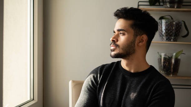 istock Young man looks thoughtfully on the windowsill on a cold winter day 1456778296