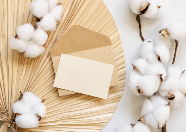 istock Blank card and envelope on dried palm leaf with cotton flowers top view, wedding mockup 1456780720